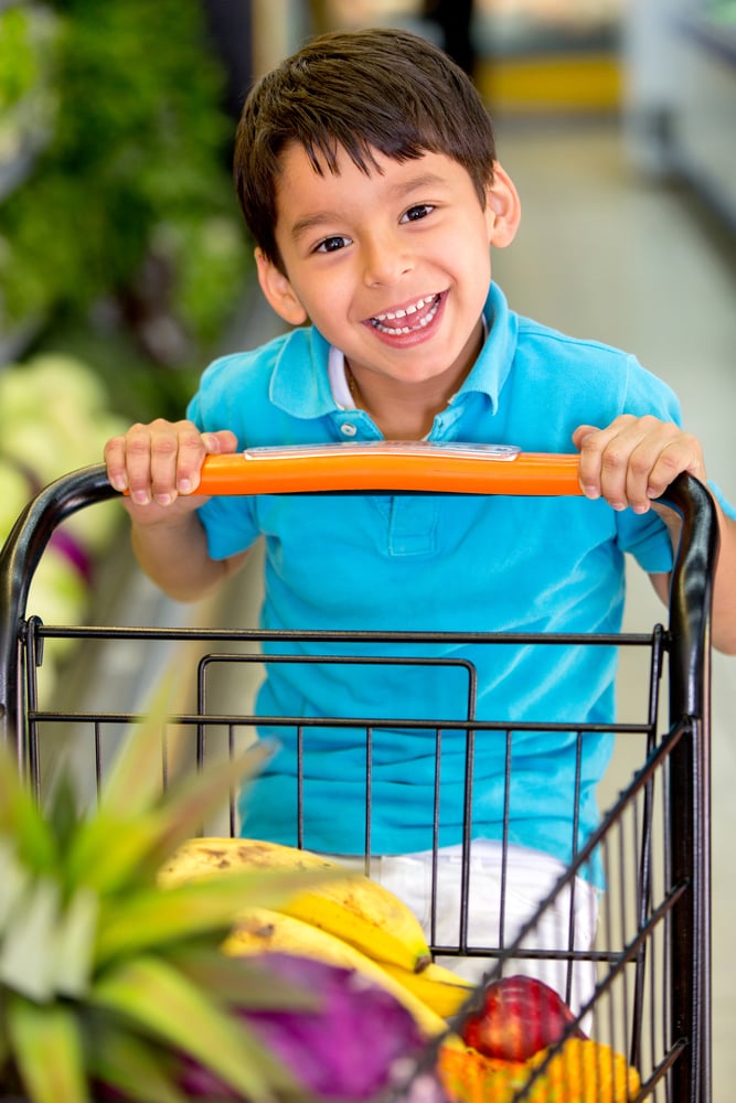 Boy playing with a shopping cart at the supermarket